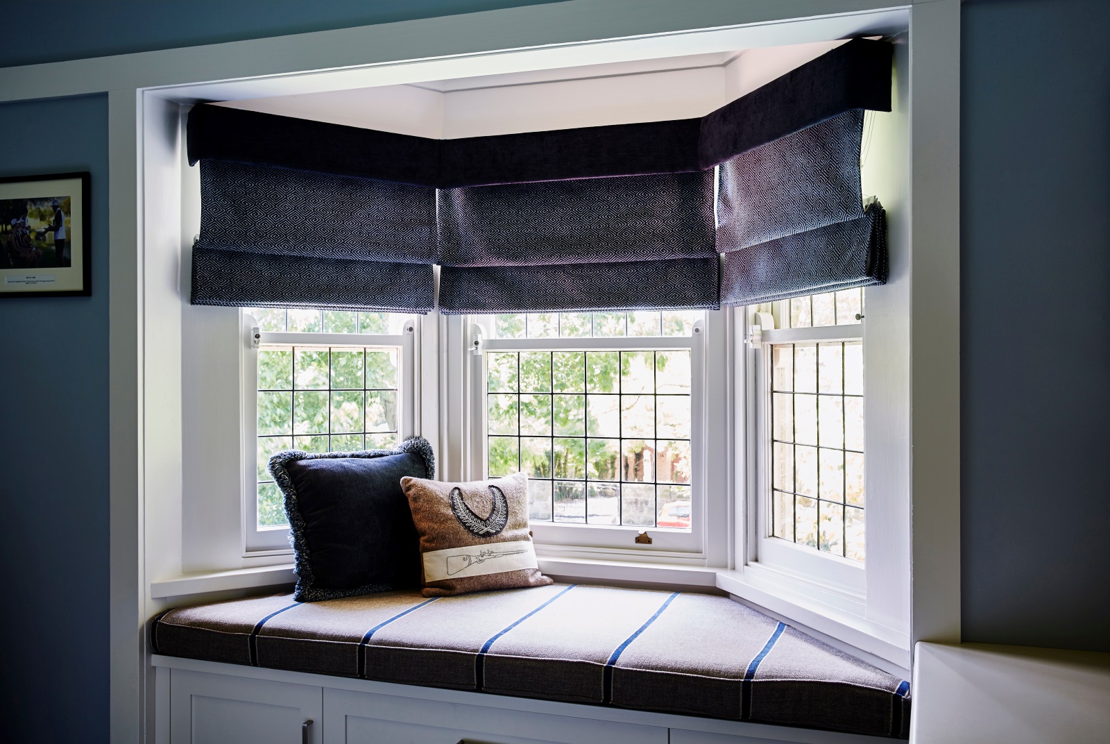 Bay window with window seat and black roman shades